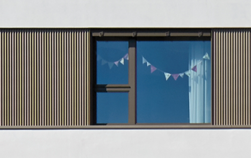 Verputz wechselt mit Fassadenprofil aus Alublech ab.